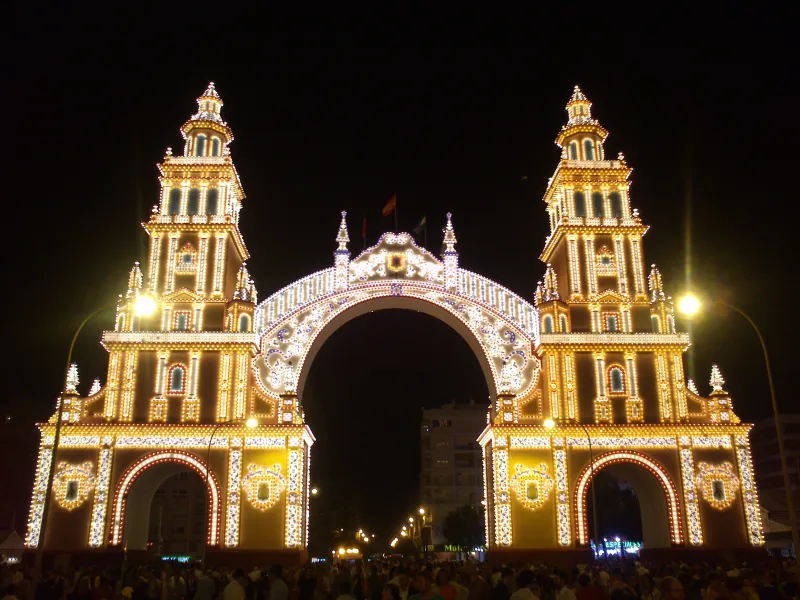The illuminated portada gateway of the Feria de Abril fairground in Seville at night