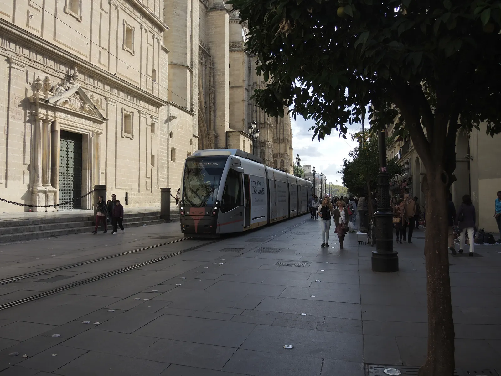 A MetroCentro tram passing Seville Cathedral on Avenida de la Constitución